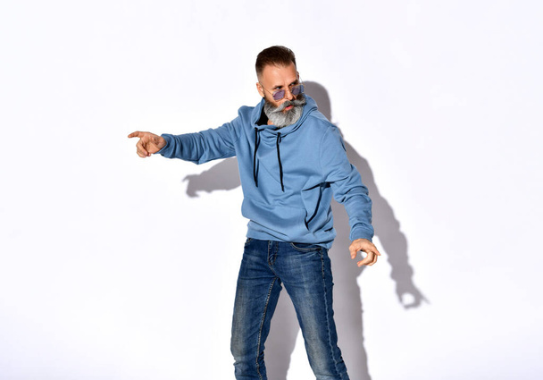 Frowning casual bearded man in motion studio shot - Photo, image