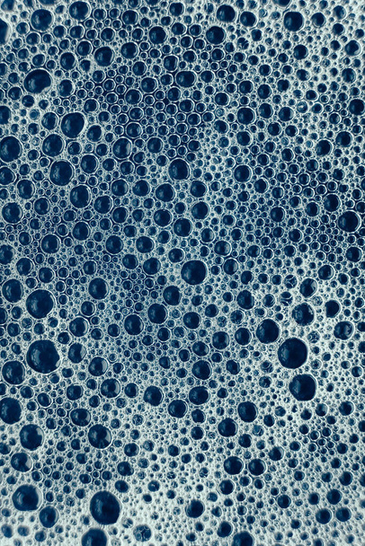 Bolle di sapone su uno sfondo di acqua blu come una texture. Vista dall'alto. Copia, spazio vuoto per il testo. - Foto, immagini