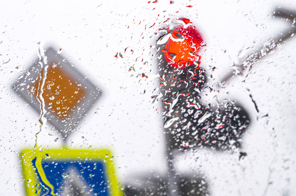 Αλεξήνεμο ενός αυτοκινήτου στέκεται σε ένα φανάρι στη βροχή. - Φωτογραφία, εικόνα