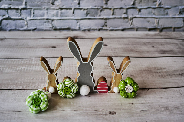 Tres conejitos de Pascua de madera por detrás con decoración. - Foto, imagen