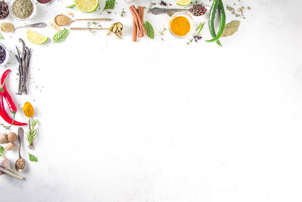 Verse kruiden, gedroogde kleurrijke specerijen. Koken achtergrond plat met verschillende kruiden, kruiden peper, vanille boon, kaneel, basilicum, rozemarijn, chili rode groene paprika 's, munt, peterselie Witte tafel bovenaanzicht - Foto, afbeelding