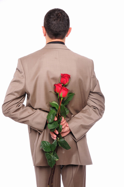 Young man hides behind a rose - Valokuva, kuva