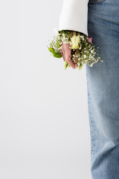 Cropped view of woman with small flowers in sleeve of jacket isolated on grey  - Photo, Image