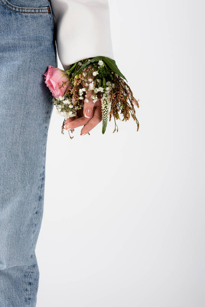 Cropped view of woman with flowers in sleeve isolated on grey  - Photo, image