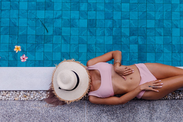 attractive fit slim woman in bikini on edge of swimming pool - Photo, Image