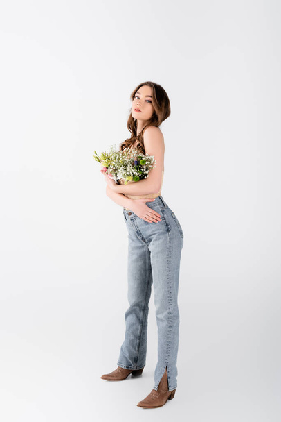 Modelo elegante com flores em blusa posando em fundo cinza - Foto, Imagem