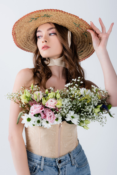 Stylish woman in sun hat and flowers in blouse isolated on grey  - Fotoğraf, Görsel