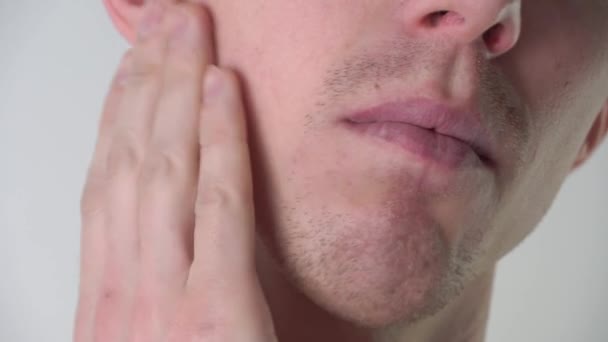 Ein junger Mann trägt im Badezimmer Schaumstoff oder Rasiergel in Nahaufnahme auf. Gesichtspflege, Rasieren von Gesichtshaaren, Stoppeln, Schnurrbart und Bart. Unrasierter Typ - Filmmaterial, Video
