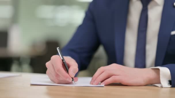 Close-up van de handen van zakenman schrijven op papier  - Video