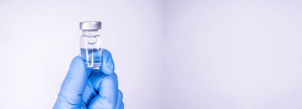 手の注射のための薬瓶,医師の手のひら.予防接種用の医療用ガラス瓶。科学機器、治療からの液体薬やワクチン、実験室でのインフルエンザ、病院や薬局。コピースペース - 写真・画像
