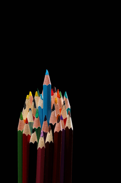 modrá barva tužka vyčnívá mezi mnoha barevných tužek na černém pozadí, selektivní zaměření. - Fotografie, Obrázek