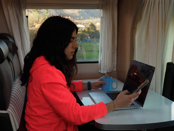 молодая кочевая женщина с ноутбуком в трейлере - Фото, изображение