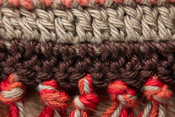 tessuto multicolore lavorato a maglia in tonalità rosse come sfondo macro foto - Foto, immagini