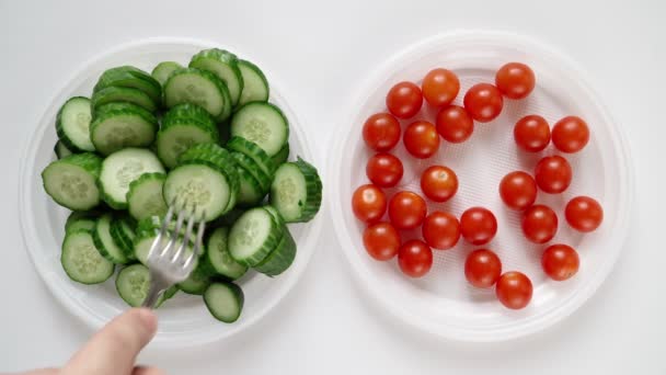 Man op dieet eet chili tomaat en komkommer van bord. Slank en gezond voedsel - Video