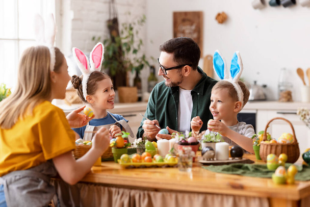 З Великоднем! сім'я мати, батько і діти фарбують яйця на свято
 - Фото, зображення