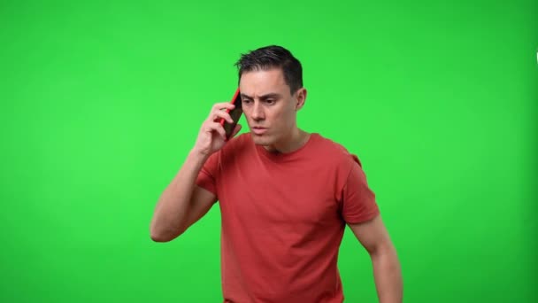 Der Mann, der am Handy spricht, ist wütend. Chromagrüner Hintergrund. - Filmmaterial, Video