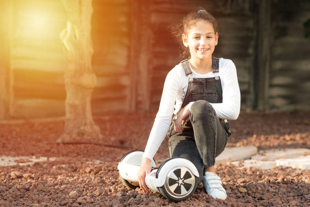 Fiatal hipster tizenéves lány kiegyensúlyozó elektromos Hover Board, Dual Wheel Self Balancing Elektromos gördeszka napos park. - Fotó, kép