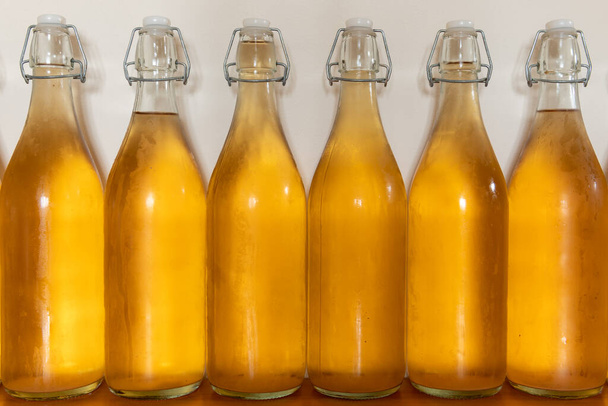 Primer plano de una fila de botellas flip top de sidra casera cubierta de condensación - Foto, Imagen