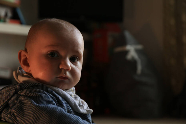 Retrato de bebé niño en una habitación doméstica dentro de la casa con luz de contraste - Foto, Imagen