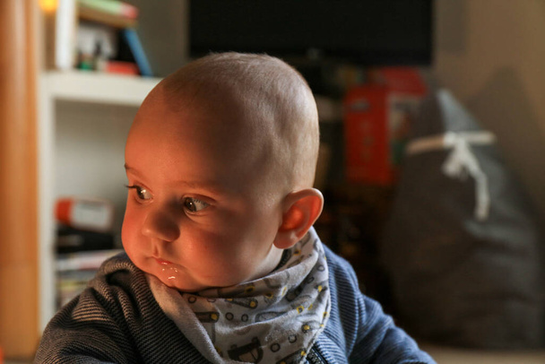 Portrait of baby boy in a domestic room inside of the house with contrast light - Photo, Image
