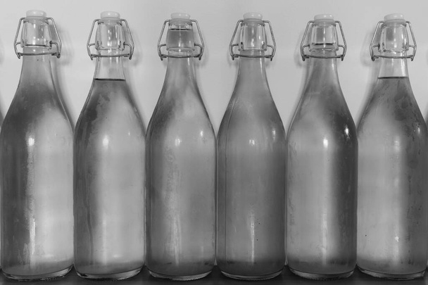 Czarno-białe zdjęcie rzędu flip top butelki domowej roboty cydru pokrytego kondensacją - Zdjęcie, obraz