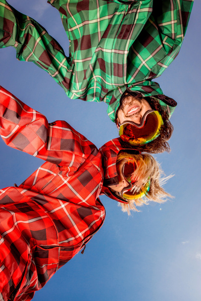 pareja en trajes de esquí con gafas de sol cogidas de la mano en el cielo azul ba
 - Foto, imagen