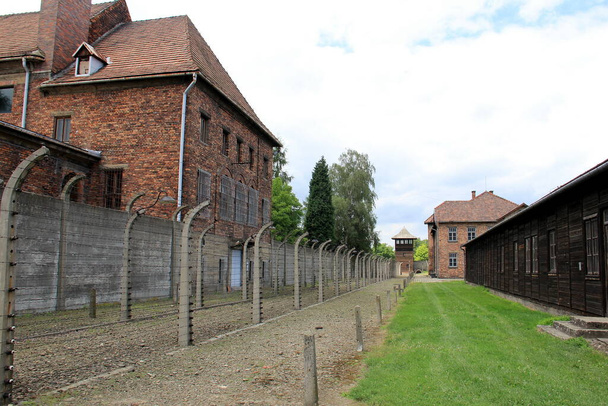 Stacheldrahtzaun und Baracken des Konzentrationslagers Auschwitz, Oswiecim, Polen - 26. Juni 2012 - Foto, Bild