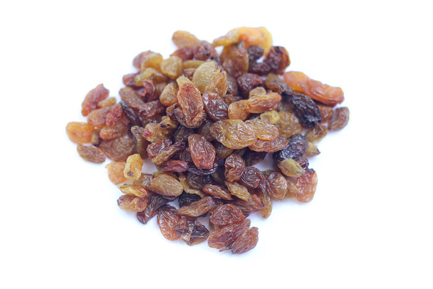 Concentration sélective sur quelques raisins secs provenant d'une pile de raisins dans un fond blanc isolé - Photo, image