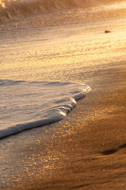 hullám tör a homok a strandon alkotó fehér hab - Fotó, kép