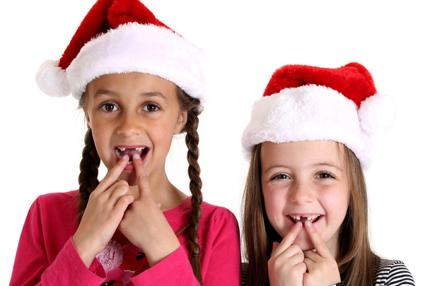 girls wearing santa hats missing their two front teeth - Photo, Image