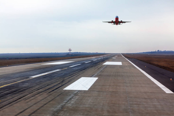 Plane is landing . Airplane over the runway strip - Photo, Image