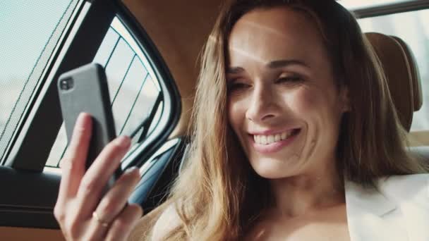 İş arabasında cep telefonuyla görüntülü konuşma yapan mutlu kadın profesyonel.. - Video, Çekim