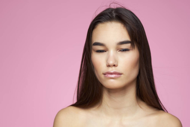 femme aux épaules nues peau claire soin du corps fond rose - Photo, image
