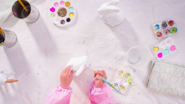 Пласка лежала. Маленька дівчинка малює папір фігурка на уроці домашнього мистецтва
. - Фото, зображення