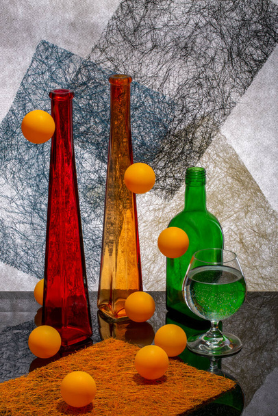 Csendélet üvegáruval és narancssárga golyókkal - Fotó, kép