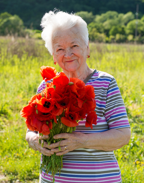 Old woman with poppies - 写真・画像