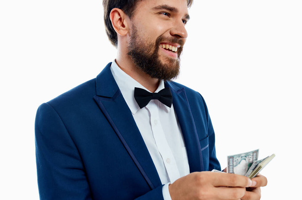 happy man with bundle of money and in classic suit on white background cropped view - Photo, Image