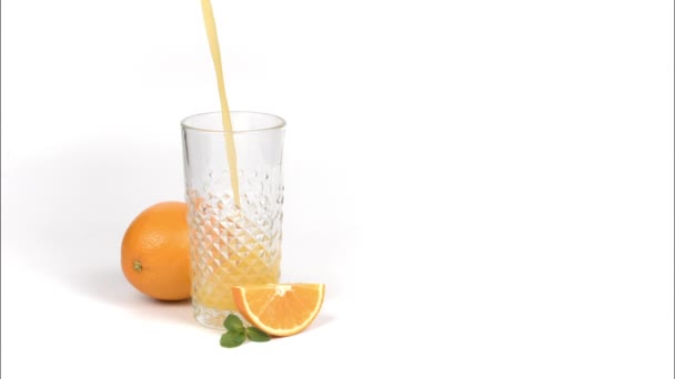 Tuoreen appelsiinimehun kaataminen lasiin valkoisella pohjalla - Materiaali, video