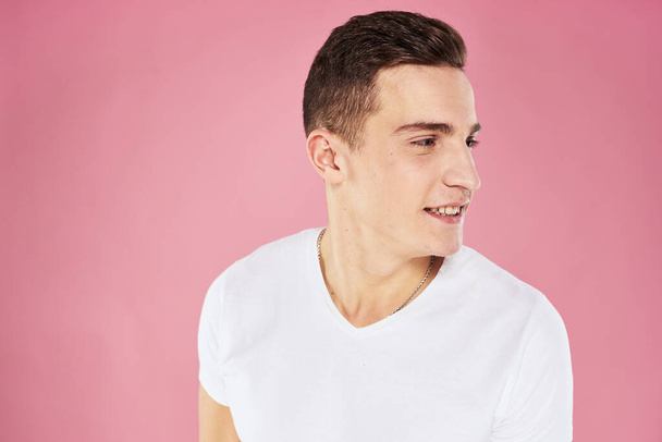 Cheerful handsome man in white t-shirt emotions pink isolated background - Foto, Imagen