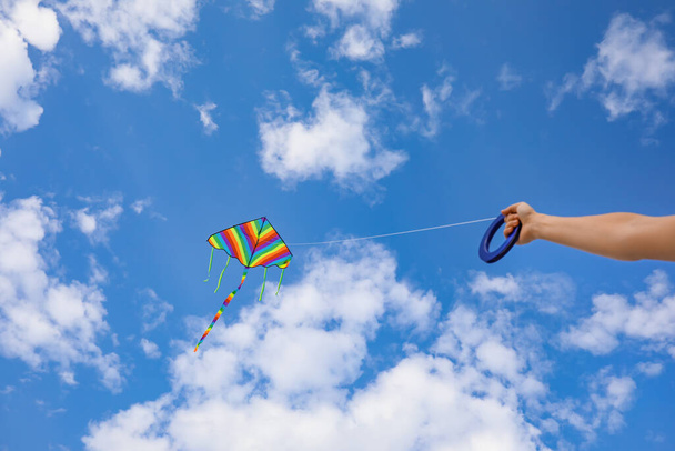 Молодая женщина запускает воздушного змея в голубом небе - Фото, изображение