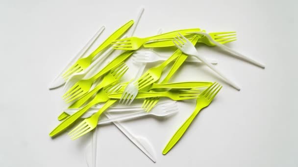 Lots of plastic forks and cutlery form a frame for text on a white background. - Footage, Video