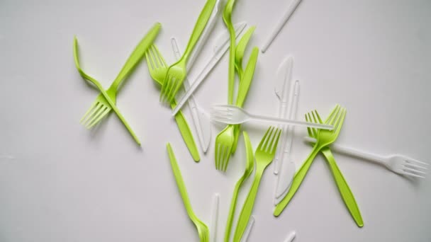 Muitos garfos de plástico e utensílios de comer estão caindo sobre fundo branco. - Filmagem, Vídeo