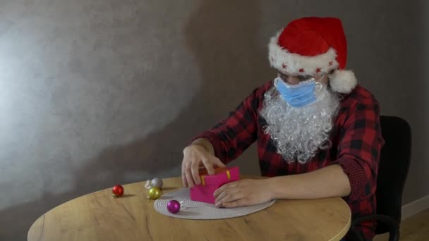 Happy Santa Claus doet een beschermend medisch masker af. Het einde van het virus. Virusbescherming. Nieuwjaarsviering in quarantaine. Coronavirus (COVID-19)). - Video