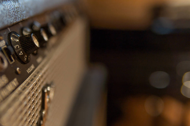 Gros plan sur le contrôle du volume d'un amplificateur de musique dans un studio d'enregistrement de musique avec un arrière-plan flou - Photo, image