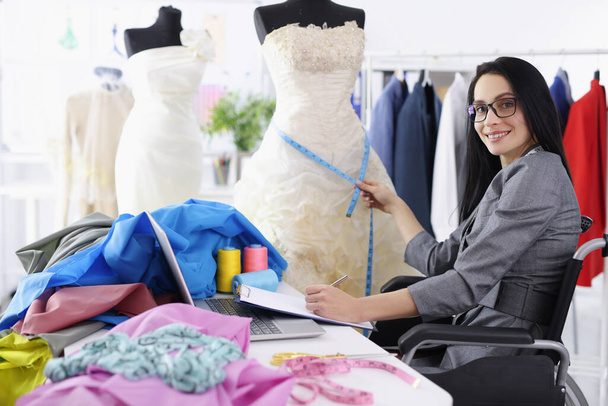 Инвалидная женщина-дизайнер предоставляет услуги по шитью свадебных платьев - Фото, изображение