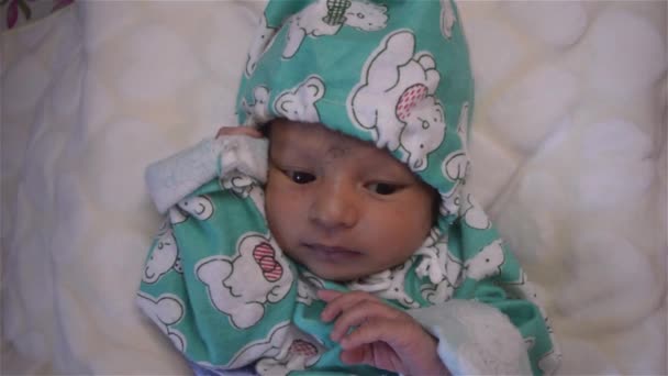 Vastasyntynyt vauva sairaalan sängyssä. Sulje videomateriaali. Kaunis ja söpö poikavauva. Lämpimiin vaatteisiin kääritty poika. Kuvaamme ennen nukkumaanmenoa.. - Materiaali, video