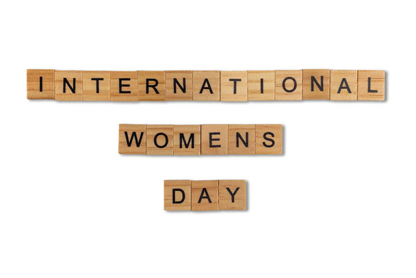 白い背景に隔離された正方形の木製のタイルからレイアウトされた単語の国際的な女性の日のトップビュー。世界と国際の日. - 写真・画像