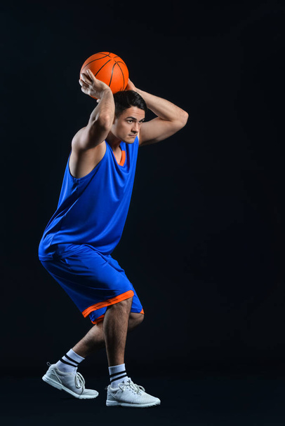 Männlicher Basketballspieler auf dunklem Hintergrund - Foto, Bild