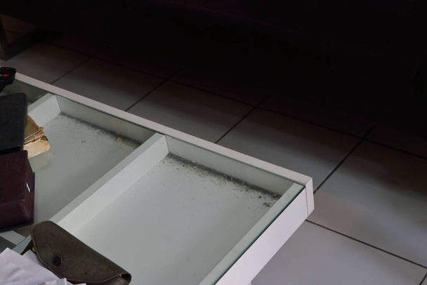 Focus selettivo di polvere sotto il piano del tavolo di vetro del tavolino disordinato in soggiorno  - Foto, immagini