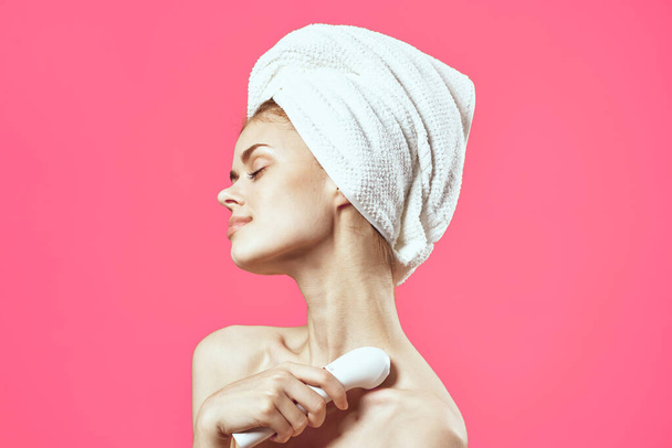 attractive woman with towel on head face massage relaxation pink background - Photo, Image